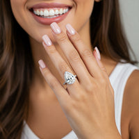 Dune pear cut diamond halo engagement ring worn on the hand, close view