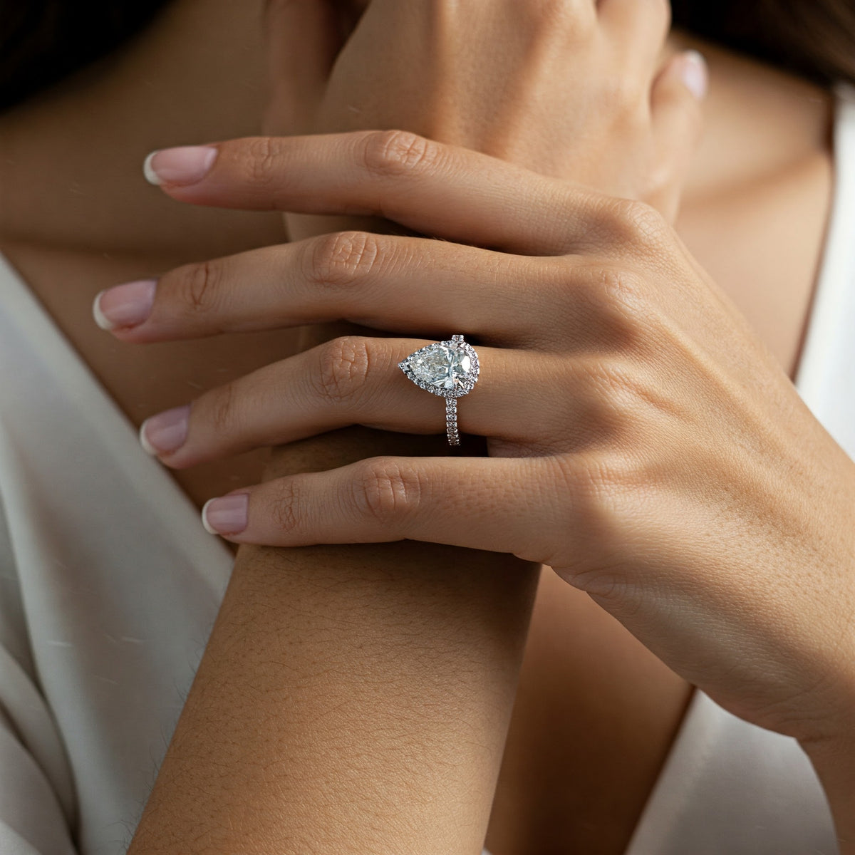 Dune pear cut diamond halo ring displayed on a girls hand — view 7
