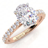 Elodie - Rose gold engagement ring with a large oval-cut center stone and small pavé-set round stones on the band, 
