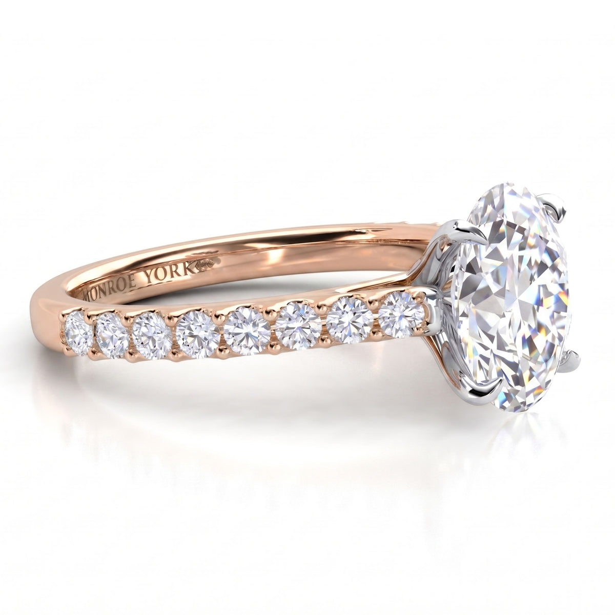 A rose gold engagement ring featuring a large oval-cut center stone and a row of smaller round stones along the band