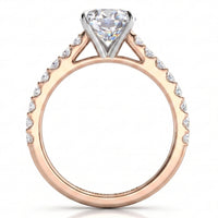 A rose gold diamond ring with a pear-cut center stone and pavé-set diamonds along the shoulders, shown on a clean white background.