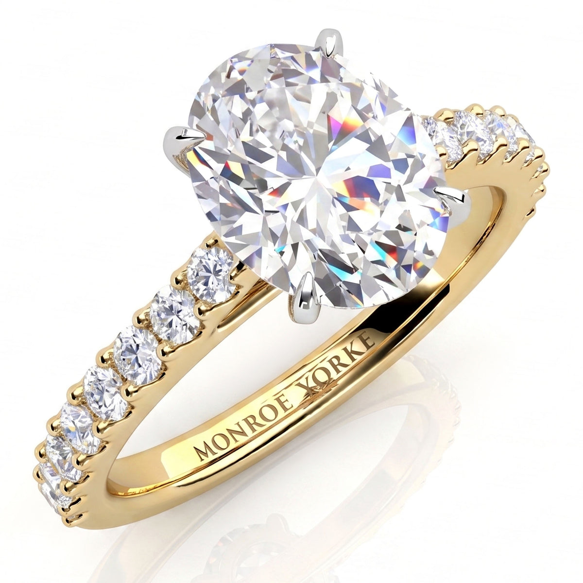 A yellow gold diamond engagement ring with a large oval-cut center stone and a pavé band featuring small round diamonds. 