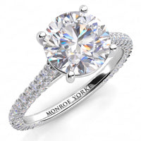 Elsie engagement ring in white gold or platinum. Round brilliant centre diamond in a four claw setting, with pave diamonds set to three sides of the band.