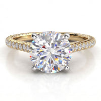 Elsie engagement ring in yellow gold, showing the four claw centre setting and the pave-set band.