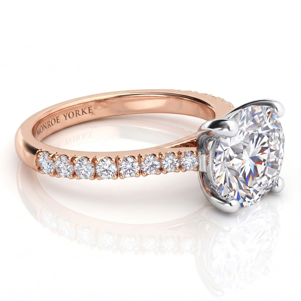 Enya rose gold engagement ring, round brilliant centre diamond above a shank set with small micro claw diamonds.