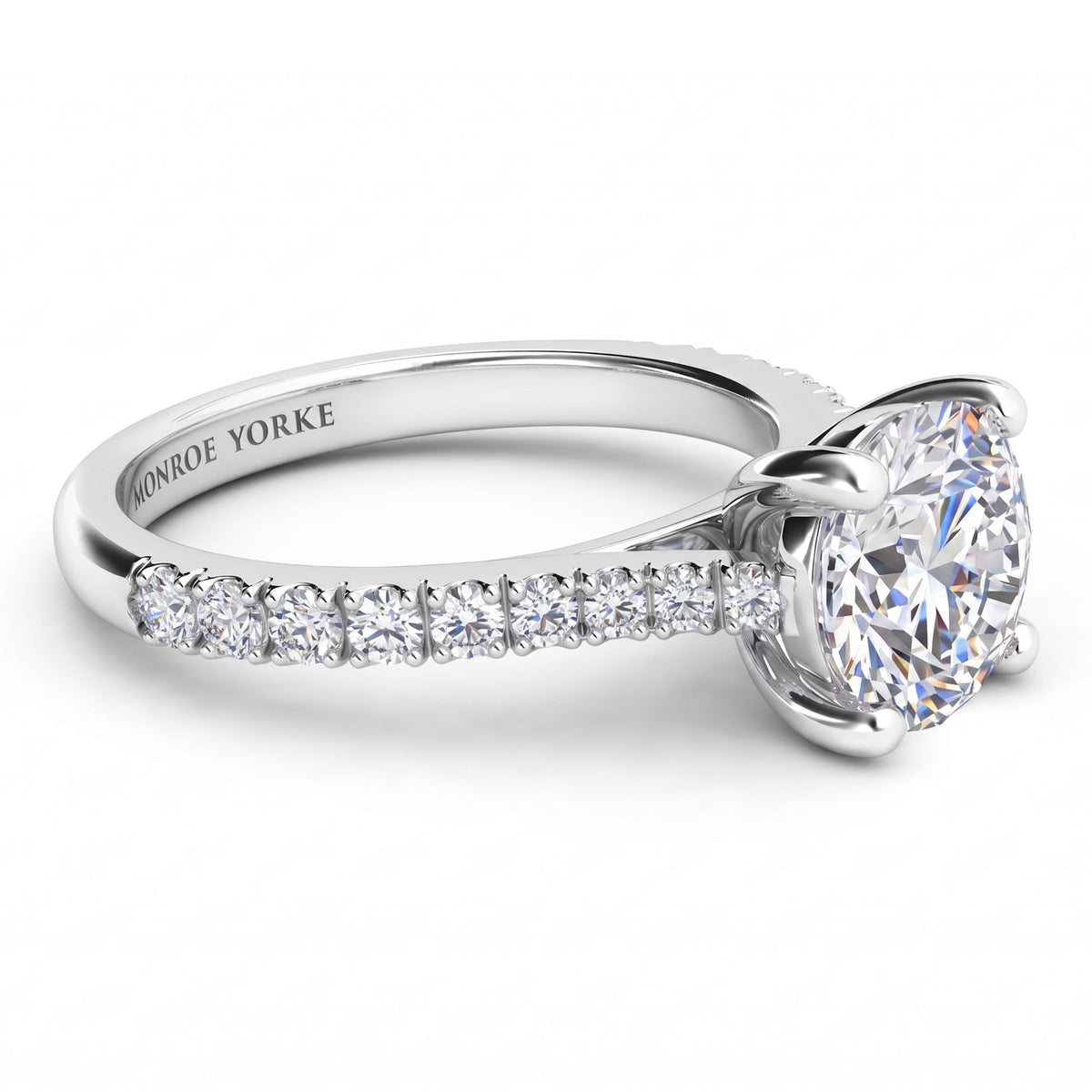 Enya engagement ring in white gold or platinum, side view of the four claw setting and the diamonds on the sweep up band.
