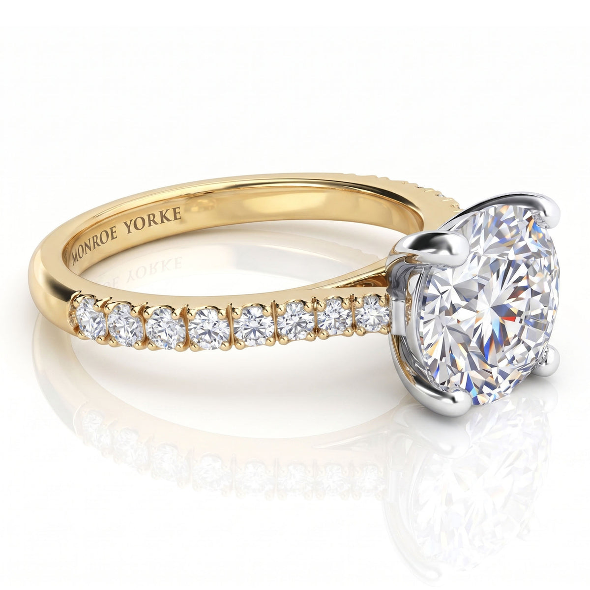 Enya yellow gold engagement ring, close view of the round brilliant centre diamond above the micro claw set shoulders.