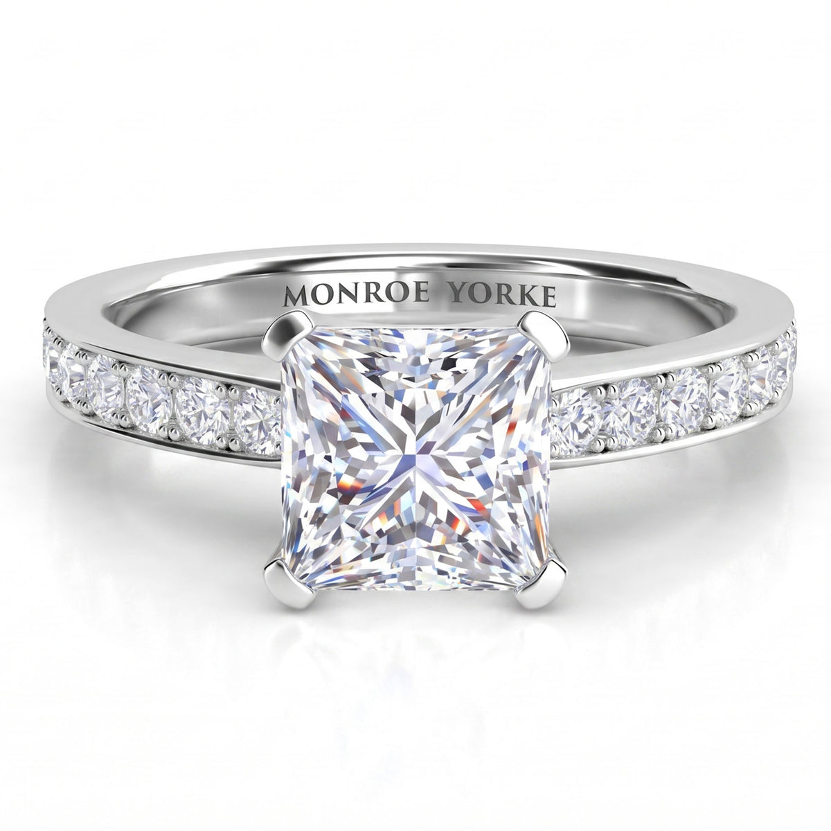 Fifth Avenue engagement ring in white gold or platinum, princess cut centre diamond with diamonds along the band.