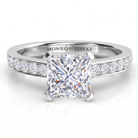 Fifth Avenue engagement ring in white gold or platinum, princess cut centre diamond with diamonds along the band.