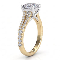 A yellow gold  split band engagement ring featuring a large  princess cut centre stone and a split shank pavé-set with smaller round stones, shown on a clean white background.