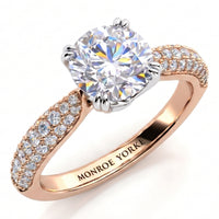 A close-up studio shot of a ring on a white background. The Harper diamond engagement ring features a large round brilliant-cut center stone in a silver-toned setting, with a rose gold band decorated with pavé-set clear stones on the shoulders.