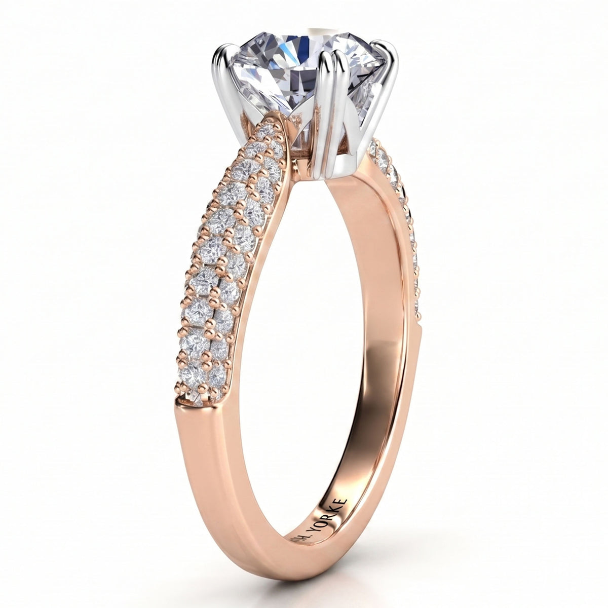 A rose gold engagement ring featuring a large round-cut clear center stone in a four-prong setting, with pavé-set clear stones along the shank. The ring is shown on a clean white background.