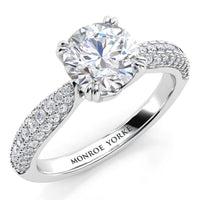 Harper - white gold or platinum diamond engagement ring with a centre ound diamond in a double claw setting.  A curved band with 3 rows of pave set diamonds. 