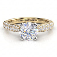 Harper - A yellow gold solitaire engagement ring with a round brilliant-cut center diamond and pavé-set diamonds along the shoulders.