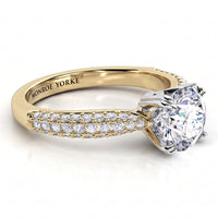 A yellow gold diamond ring with a large round-cut center stone and pavé-set diamonds along the band. 