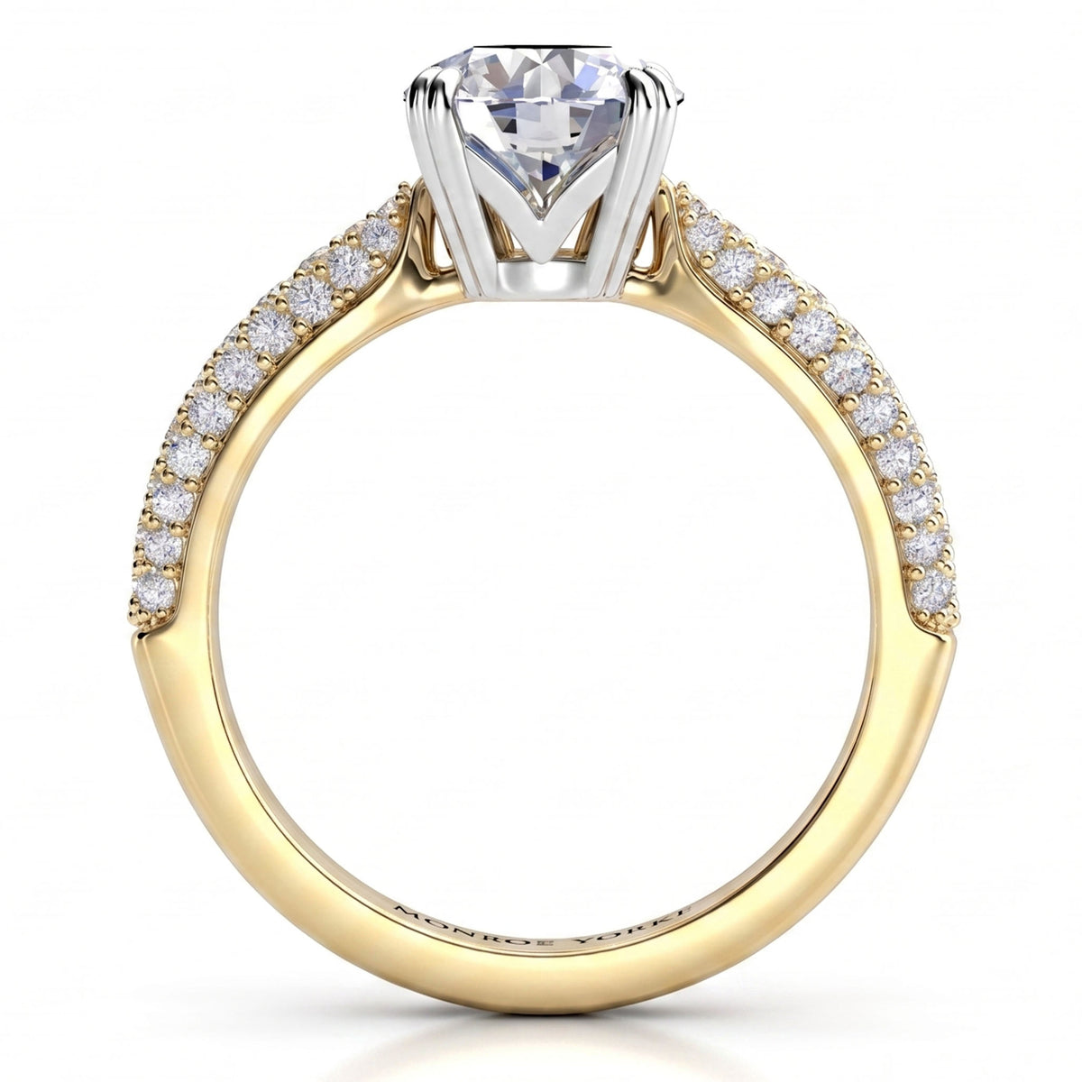 A yellow gold engagement ring featuring a large round-cut center stone and a pavé band with small clear accent stones, shown on a clean white background.