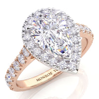 Iris - A pear-cut diamond halo ring in rose gold, featuring a large central pear diamond surrounded by a diamond halos and a shank band with small round diamonds. 