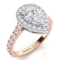 Iris - A pear shaped diamond halo ring in rose gold, featuring a large central pear shaped diamond surrounded by a diamond halos and a band with small round diamonds. 