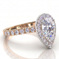 Iris - A pear shaped diamond halo ring in rose gold, featuring a large central pear shaped diamond surrounded by a diamond halos and a band with diamonds. 