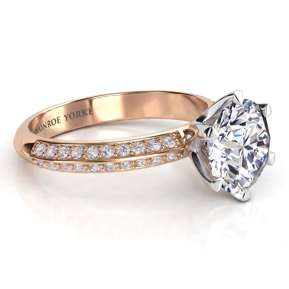 Juliet engagement ring in rose gold. Knife edge band with pave-set diamonds and a round brilliant centre in a six claw setting.