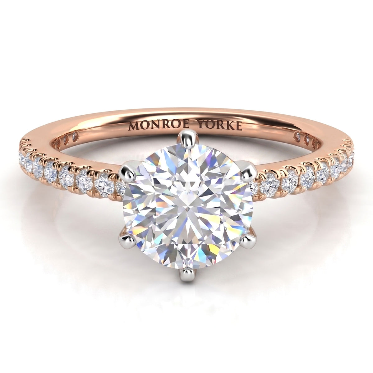 A rose gold solitaire engagement ring with a round brilliant-cut center diamond and small pavé diamonds on the band.