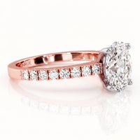 A rose gold diamond ring with a large oval-cut center stone and a row of smaller diamonds along the band.