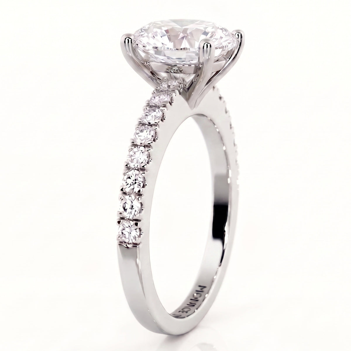 Side view of Kendall in white gold or platinum engagement ring with an oval cut diamond center stone and a pavé-set diamond band.