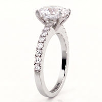 Side view of Kendall in white gold or platinum engagement ring with an oval cut diamond center stone and a pavé-set diamond band.
