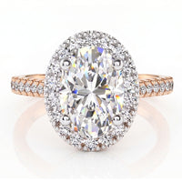 An oval halo ring featuring a large oval-cut center diamond surrounded by a halo of smaller diamonds, set on a rose gold band with pavé diamonds.