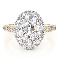 An oval halo ring featuring a large oval-cut center stone surrounded by a halo of smaller stones, set on a yellow gold band with pavé accents.