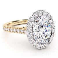 An oval-cut diamond halo ring with a yellow gold band accented by small diamonds.
