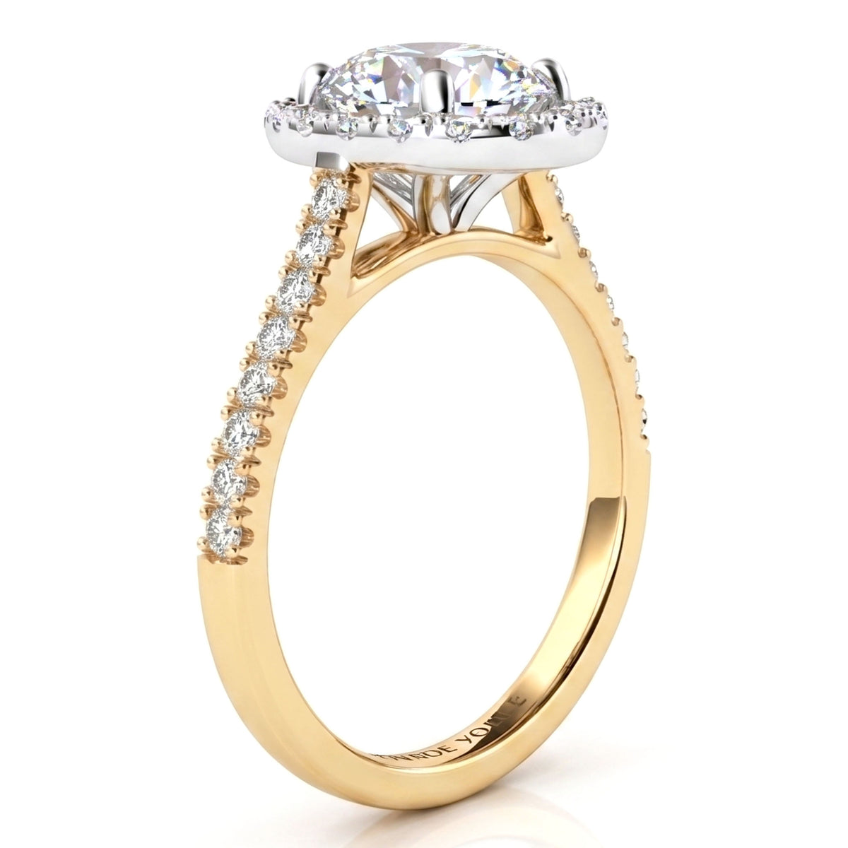 A yellow gold engagement ring featuring a oval-cut center stone in a halo setting, with a pavé band accented by small round stones.