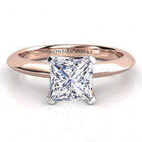 A princess cut diamond solitaire ring set in a rose gold band, with the brand name 'MONROE YORKE' engraved on the inside of the band. The ring is shown on a clean white background with a soft reflection.