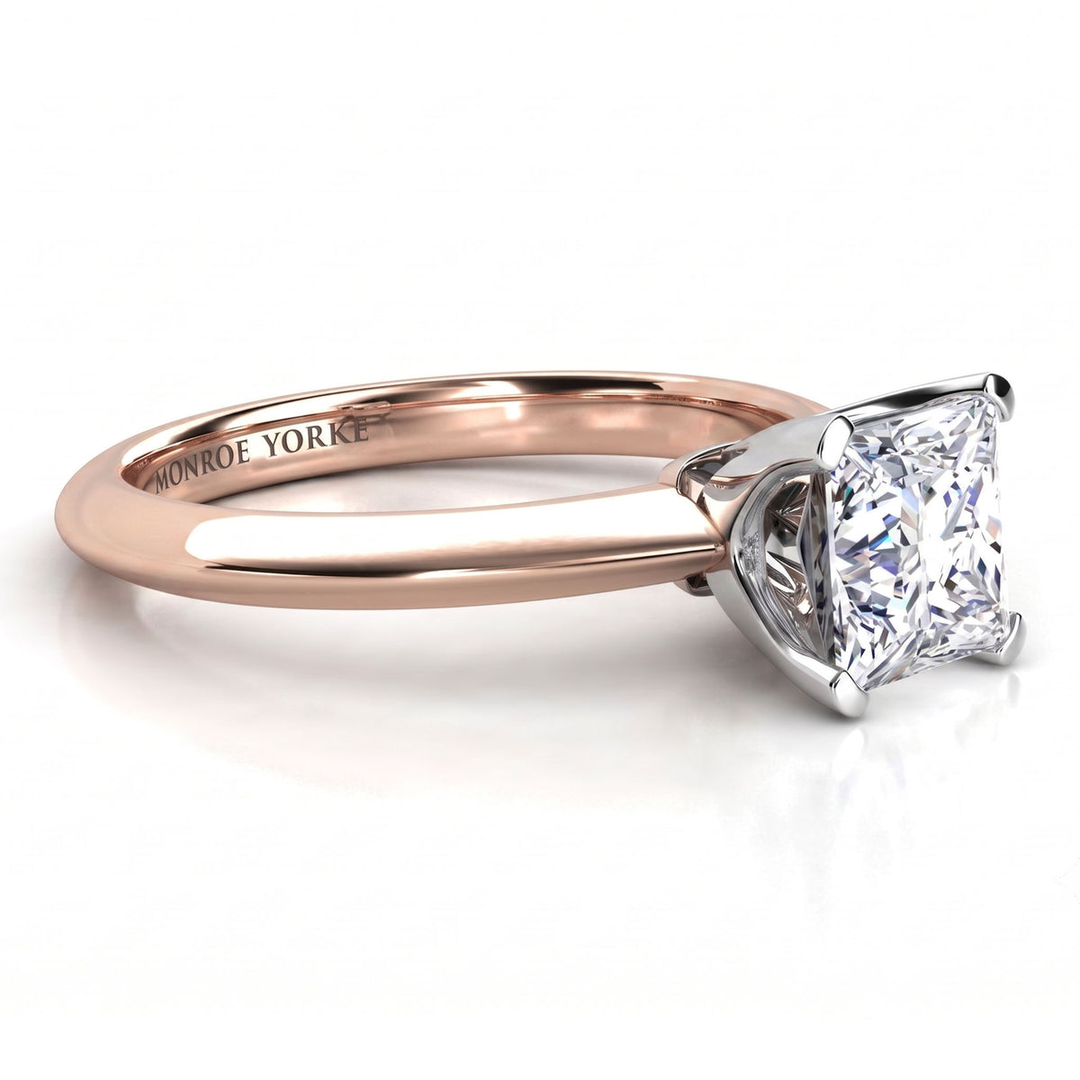 A close-up studio shot of a classic princess cut diamond solitaire engagement ring. The ring features a rose gold band with a polished white metal four-prong setting holding the diamond.