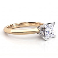 A Monroe Yorke engagement ring featuring a princess cut diamond set in a white metal four-prong setting on a yellow gold band, shown on a clean white background.