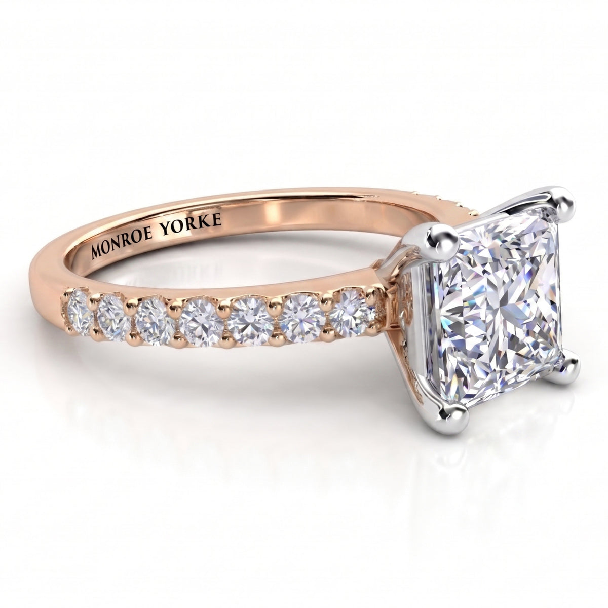 Lutèce rose gold engagement ring, low side view showing the princess cut centre diamond and the diamond set shoulders.