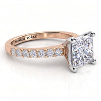 Lutèce rose gold engagement ring, low side view showing the princess cut centre diamond and the diamond set shoulders.