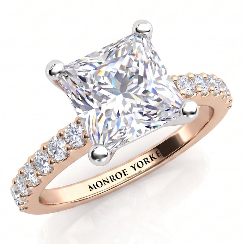 Lutèce rose gold engagement ring, angled view of the princess cut centre diamond in a four claw setting with micro claw set diamonds along the shoulders, Monroe Yorke engraved on the band.