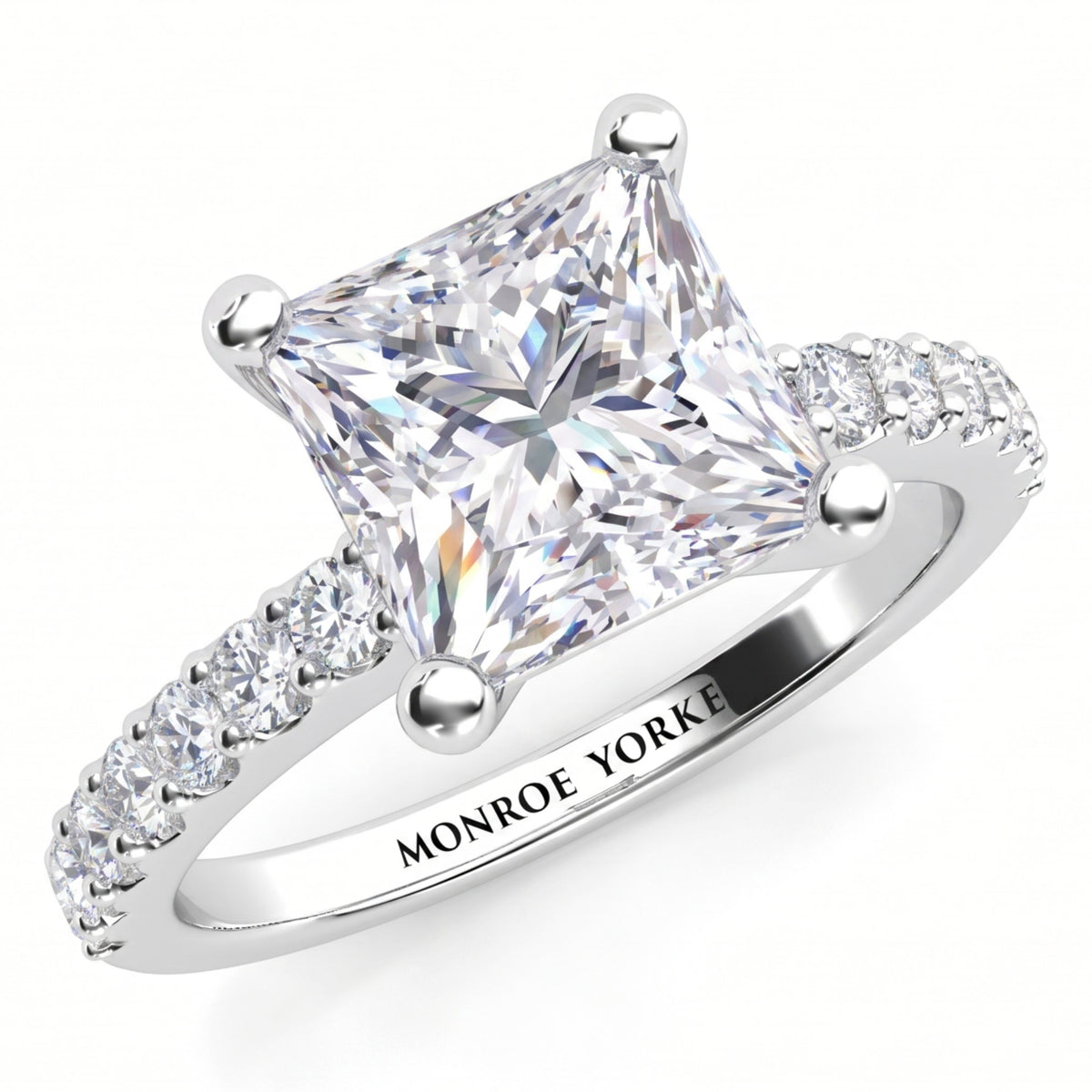 Lutèce engagement ring in white gold or platinum, angled view of the princess cut centre diamond in a four claw setting, Monroe Yorke engraved on the band.