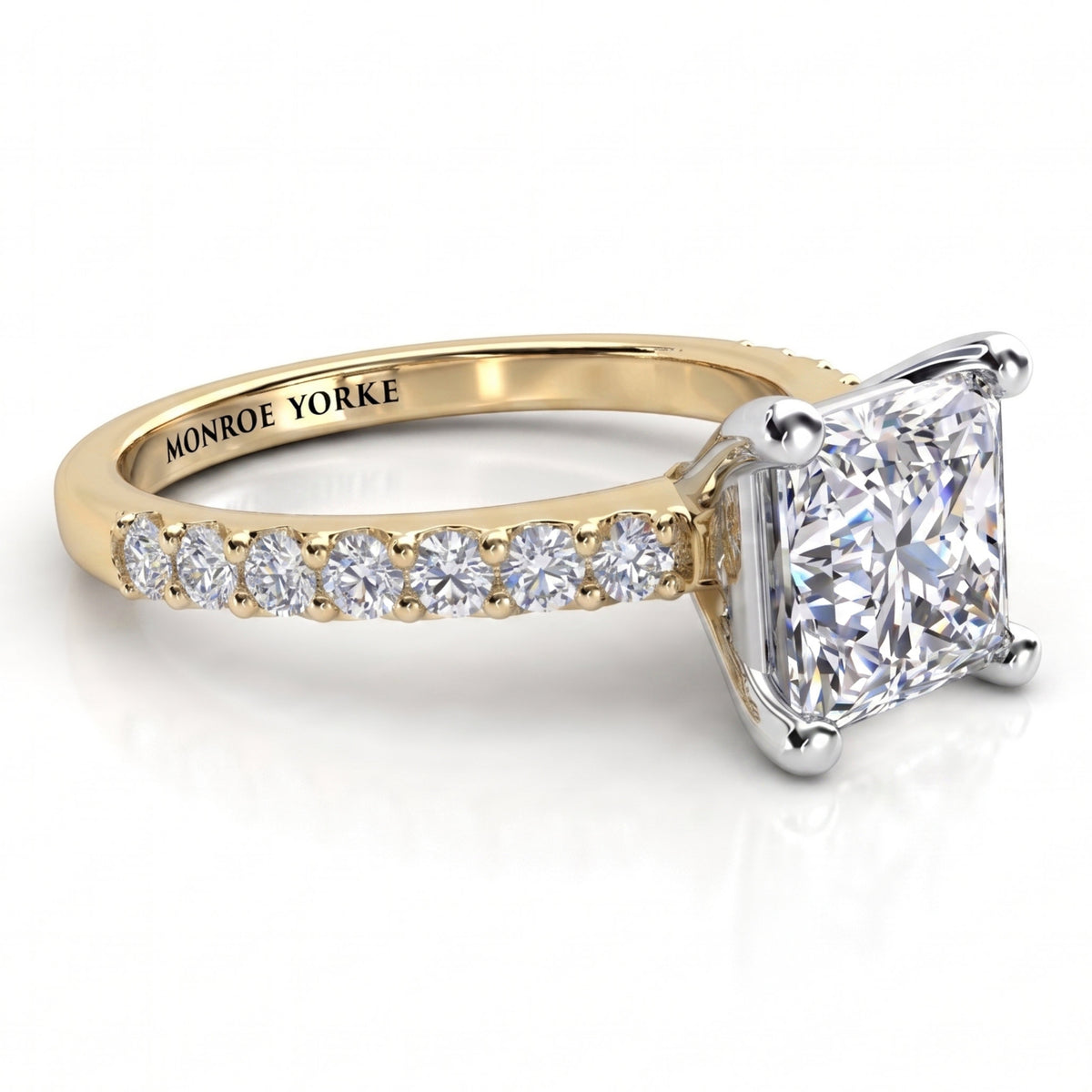 Lutèce yellow gold engagement ring, low side view showing the princess cut centre diamond and the diamond set shoulders.