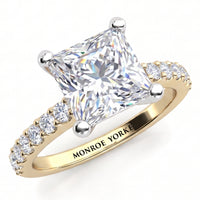 Lutèce yellow gold engagement ring, angled view of the princess cut centre diamond in a four claw setting with micro claw set diamonds along the shoulders, Monroe Yorke engraved on the band.