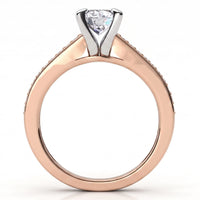 A close-up studio shot of a diamond engagement ring with a rose gold band and a silver-colored three-prong setting holding a round brilliant-cut diamond.