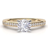 May - yellow gold solitaire engagement ring featuring a round brilliant-cut center stone in a 4 claw setting and a pavé band set with small round diamonds, shown on a clean white background.