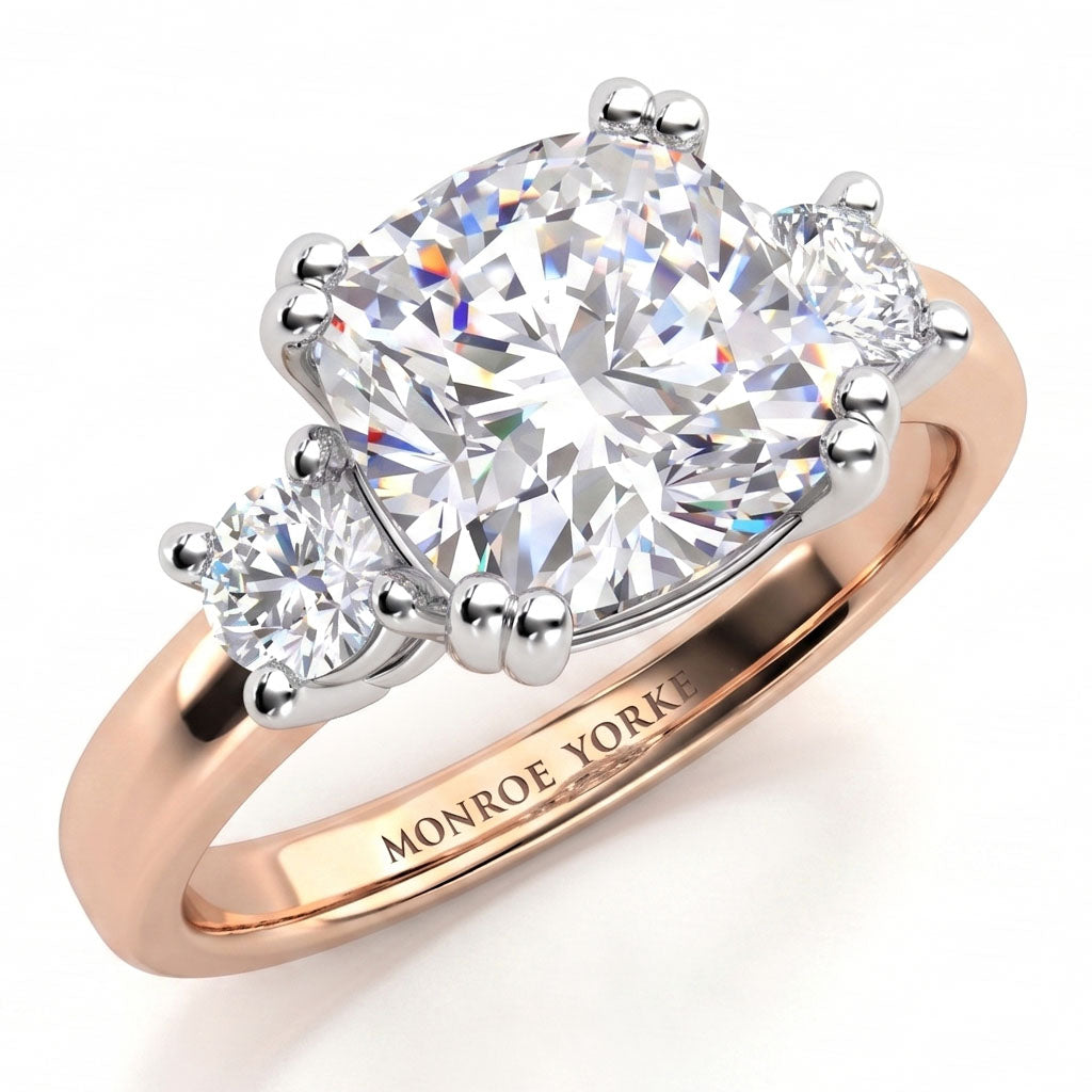 Meghan Markle engagement ring. Three diamond ring with centre certified cushion cut diamond and round diamonds on either side. Rose Gold Band