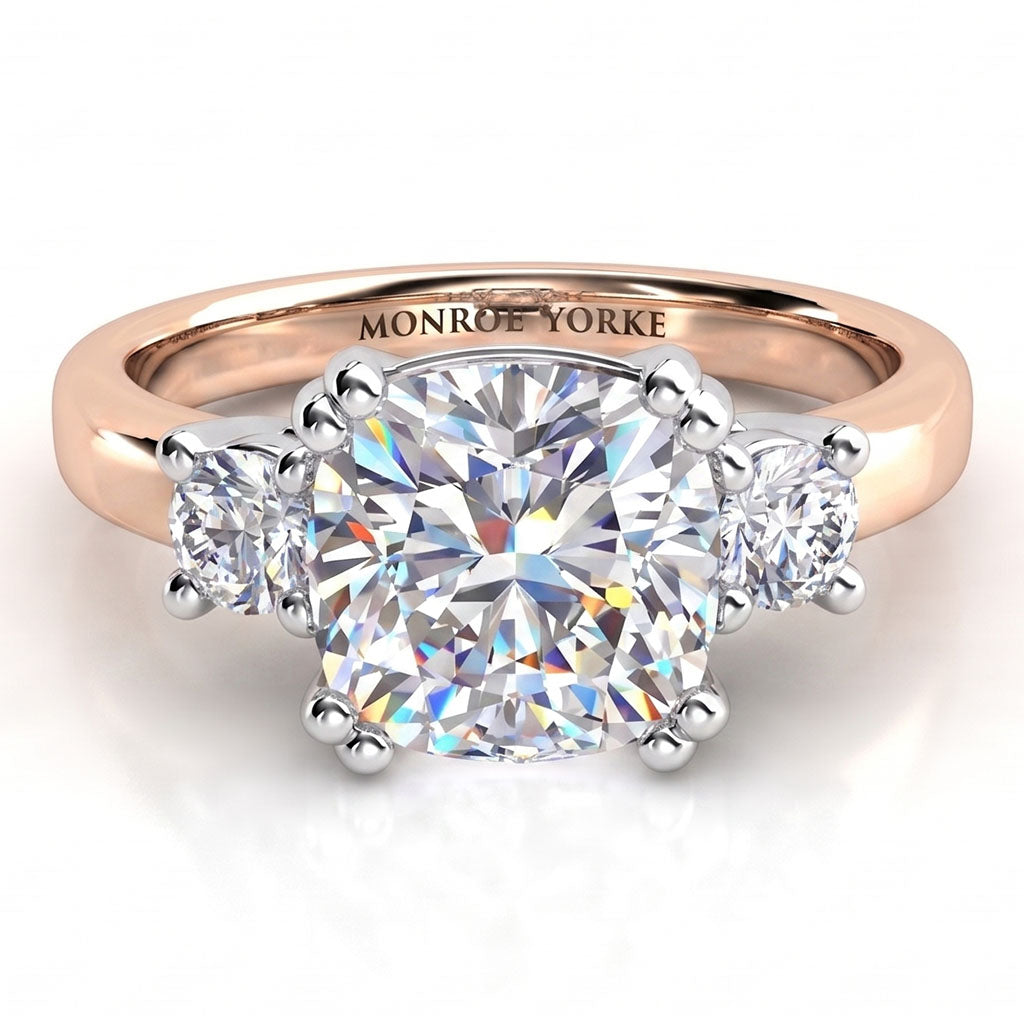 Meghan Markle's diamond engagement ring in rose gold. Three diamond ring with centre certified cushion cut diamond and round diamonds on either side. Rose Gold Band