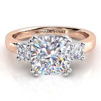 Meghan Markle's diamond engagement ring in rose gold. Three diamond ring with centre certified cushion cut diamond and round diamonds on either side. Rose Gold Band