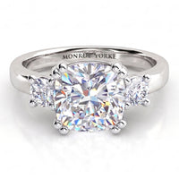 Meghan Markle's engagement ring. Three diamond ring with centre cushion cut diamond and round diamonds on either side. White Gold or platinum