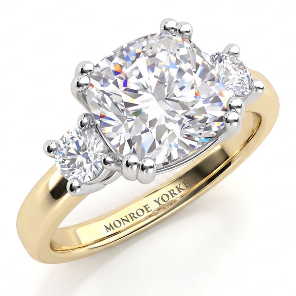 Meghan Markle engagement ring. Three diamond ring with centre GIA certified cushion cut diamond and round diamonds on either side. Yellow Gold Band