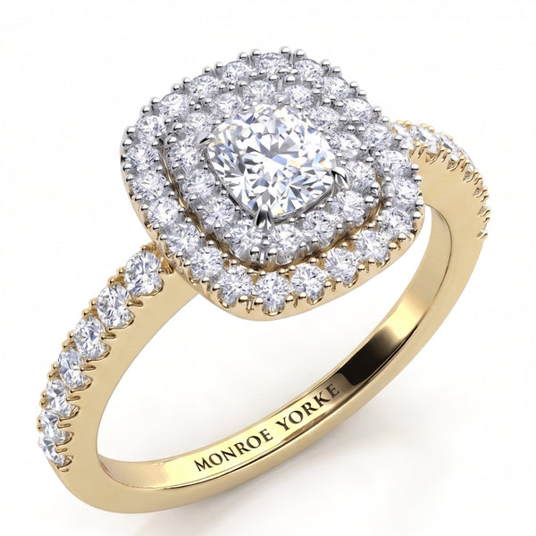 Norah double halo cushion cut engagement ring in yellow gold, angled view of the cushion cut centre diamond framed by two diamond halos in a white metal setting head, Monroe Yorke engraved inside the band.