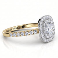 Norah cushion cut double halo engagement ring with a yellow gold band, angled side view showing the depth of the two halos in the white metal setting head.